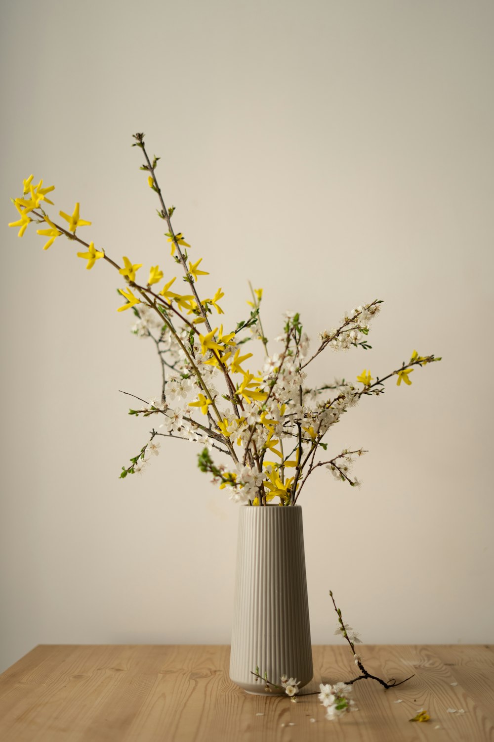 a vase filled with yellow flowers on top of a wooden table