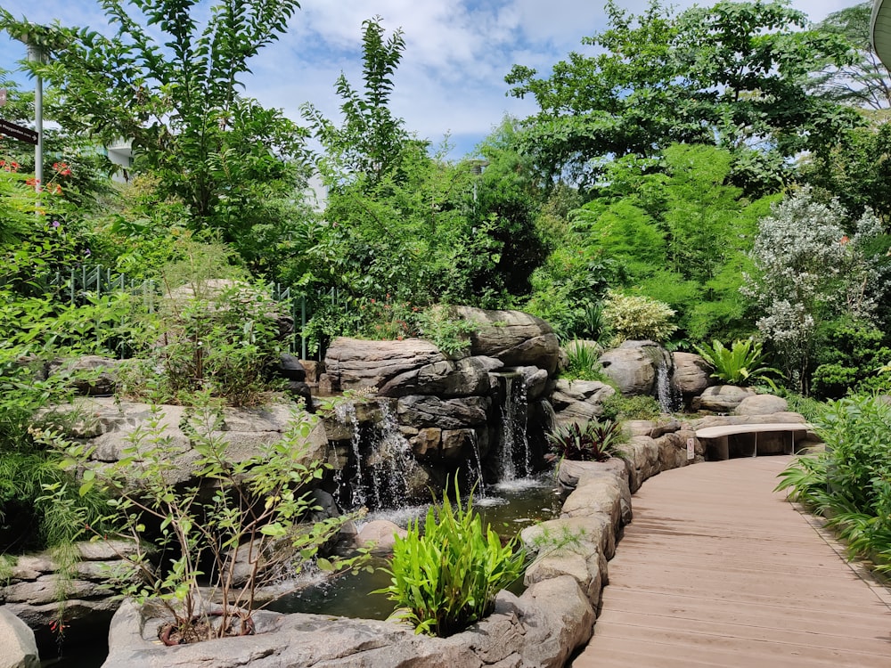 a wooden walkway leading to a waterfall in a park