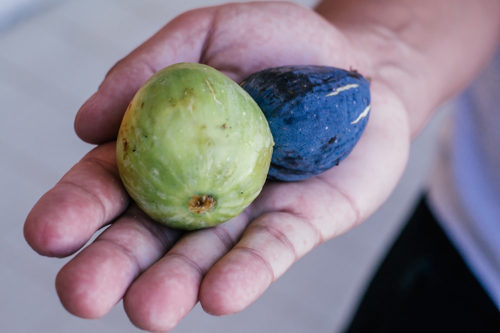 a person holding two different types of fruit in their hands