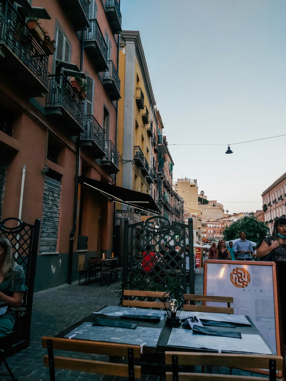 a group of people sitting at a table in an alleyway