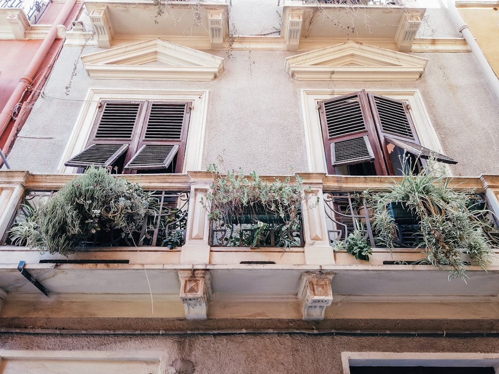 a building with two balconies filled with plants