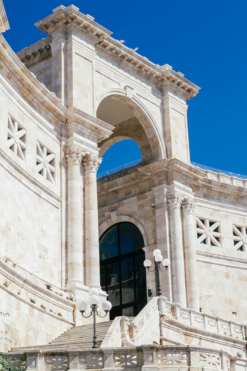 um grande edifício branco com um relógio ao seu lado