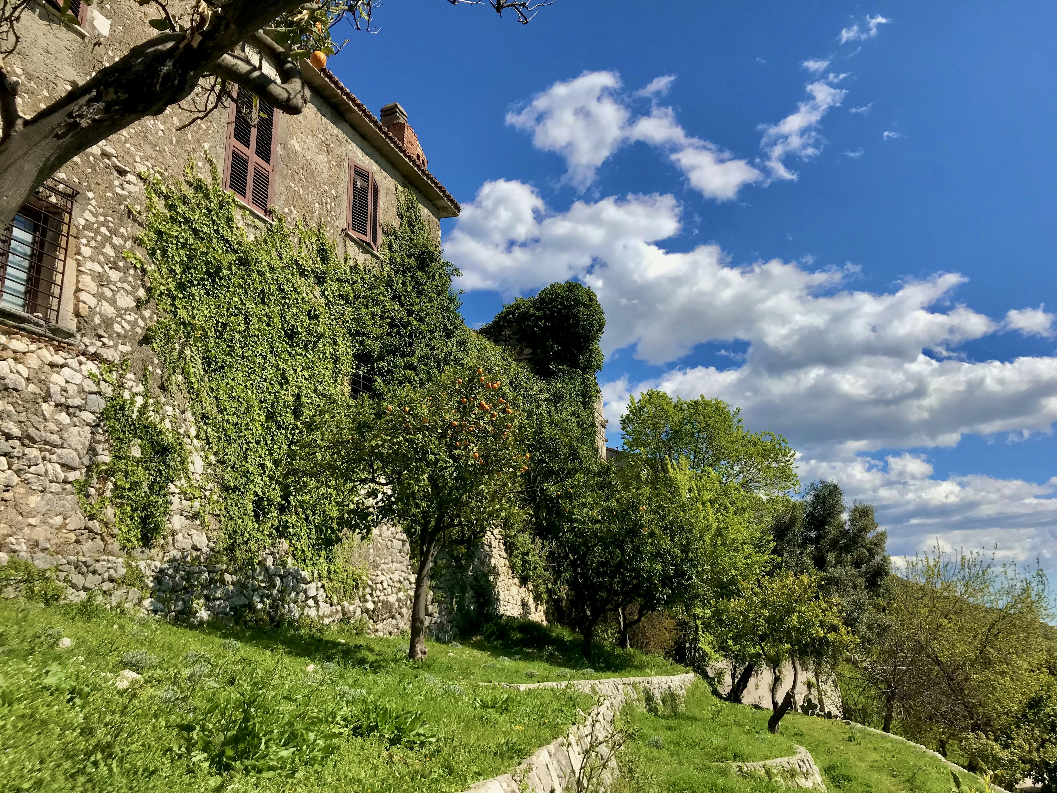 a stone building with trees on the side of it
