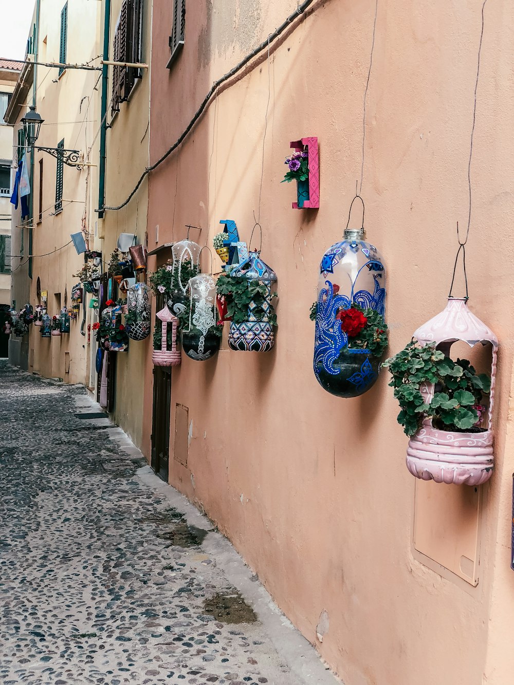 a row of hanging planters on the side of a building