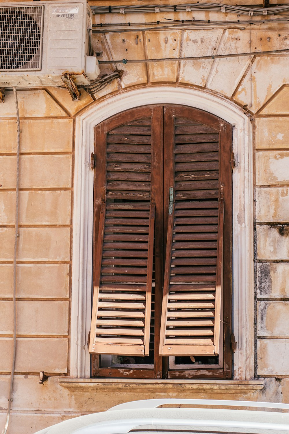 a car parked in front of a window with wooden shutters