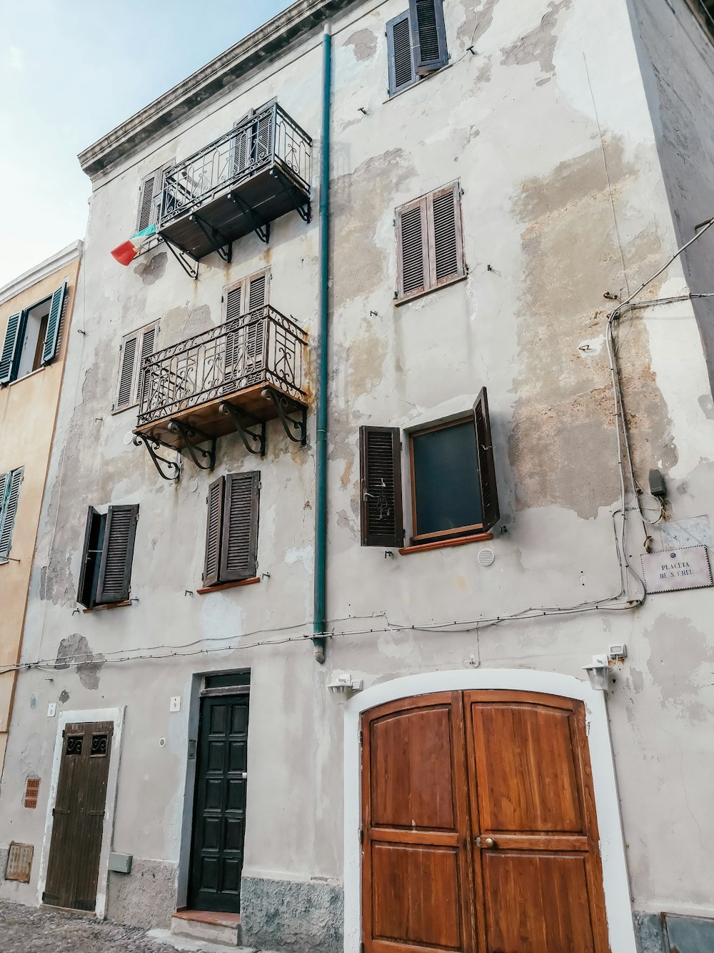 an old building with two doors and a balcony