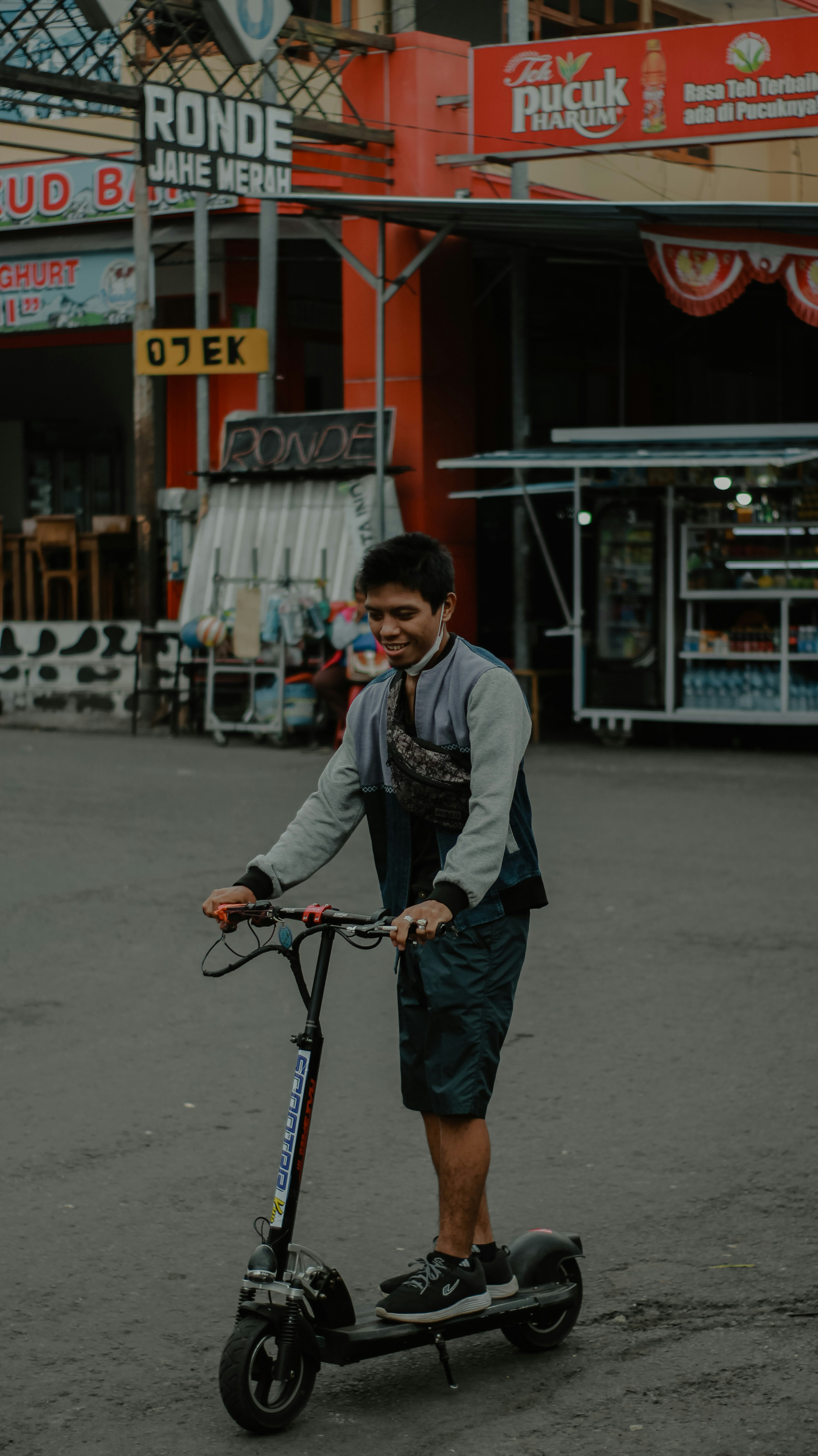 A man riding a scooter on a city street