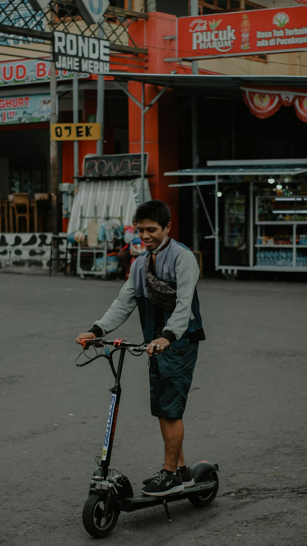 a man riding a scooter on a city street