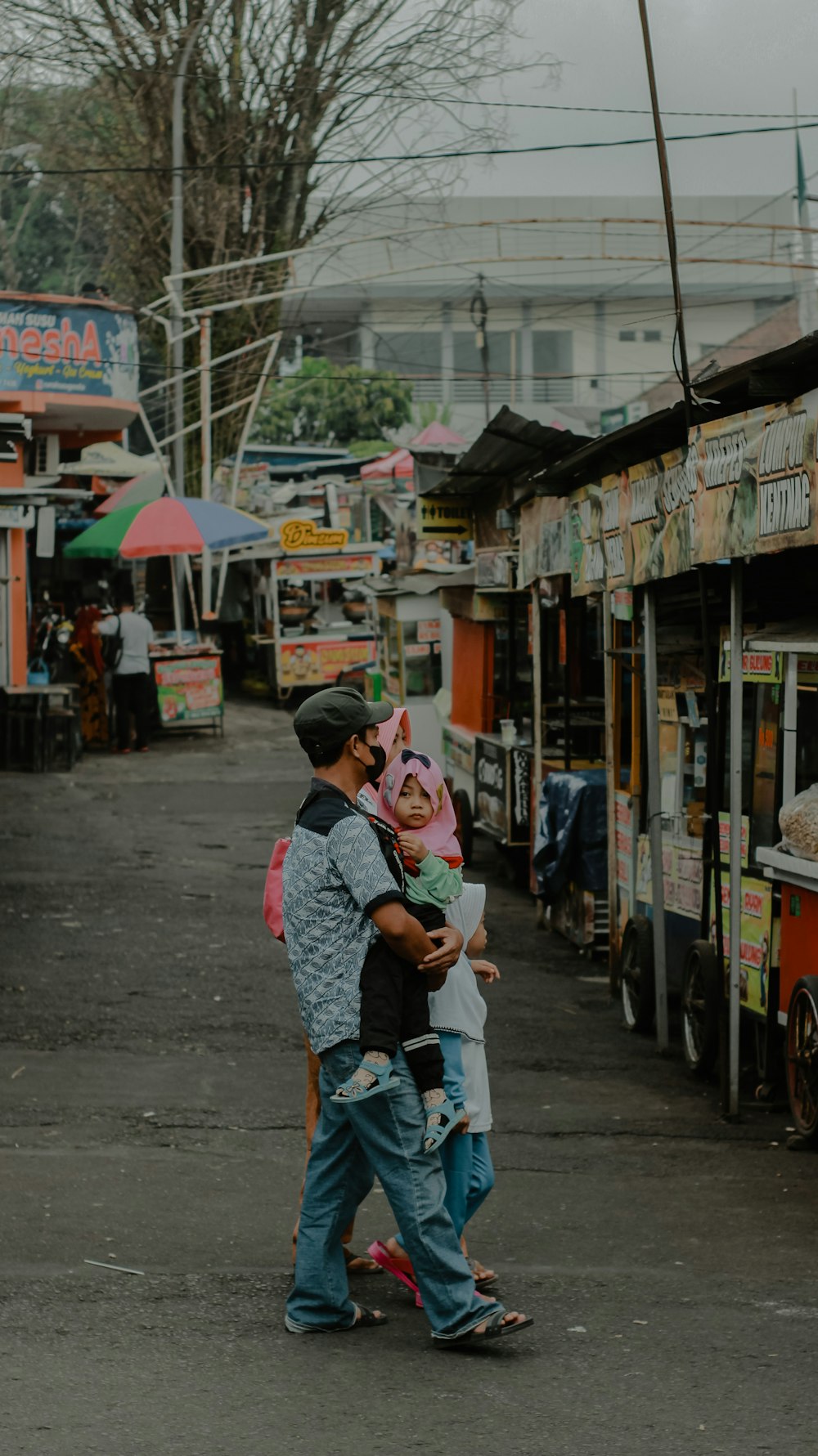 a man walking down a street holding a child