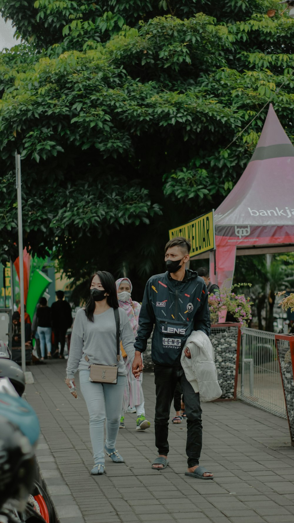 a man and a woman walking down a sidewalk