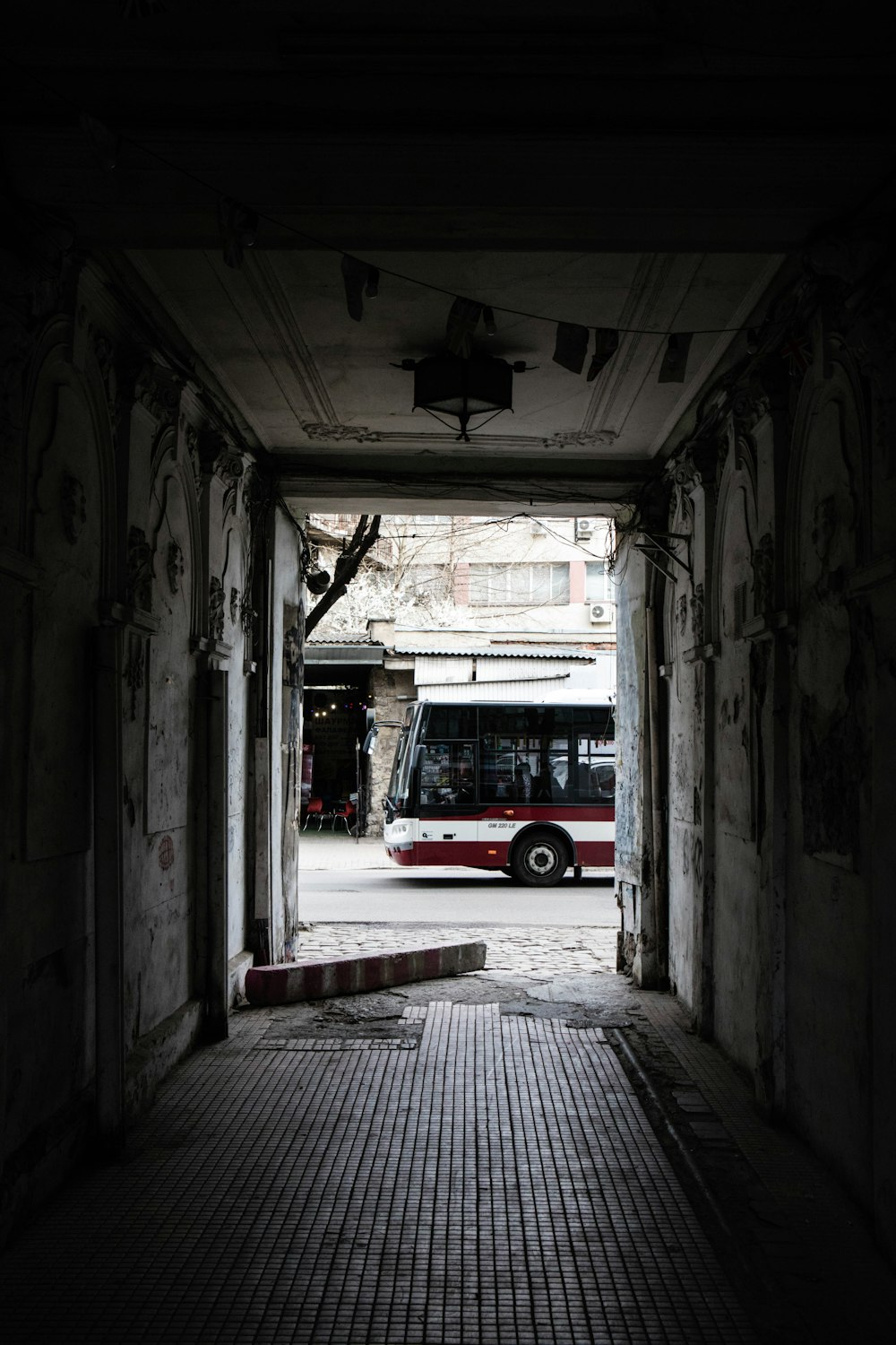 a red and white bus parked in a tunnel