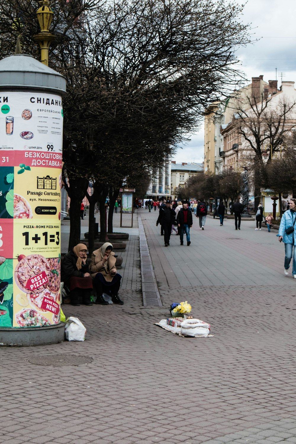 a person sitting on the ground next to a pole