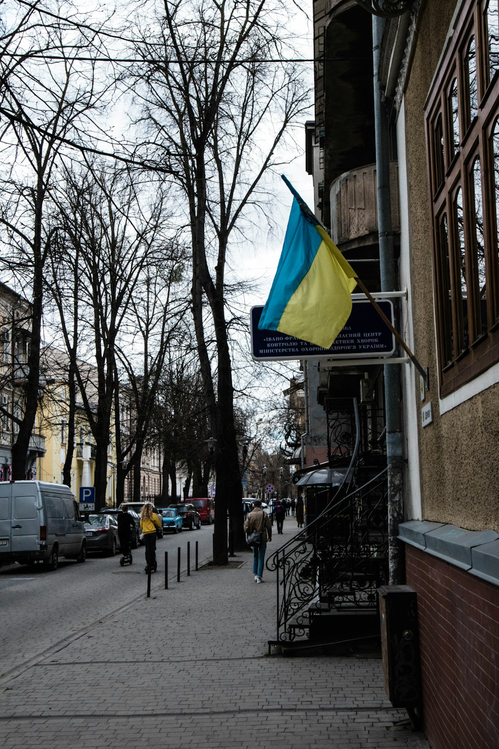 a blue and yellow flag is hanging on a building