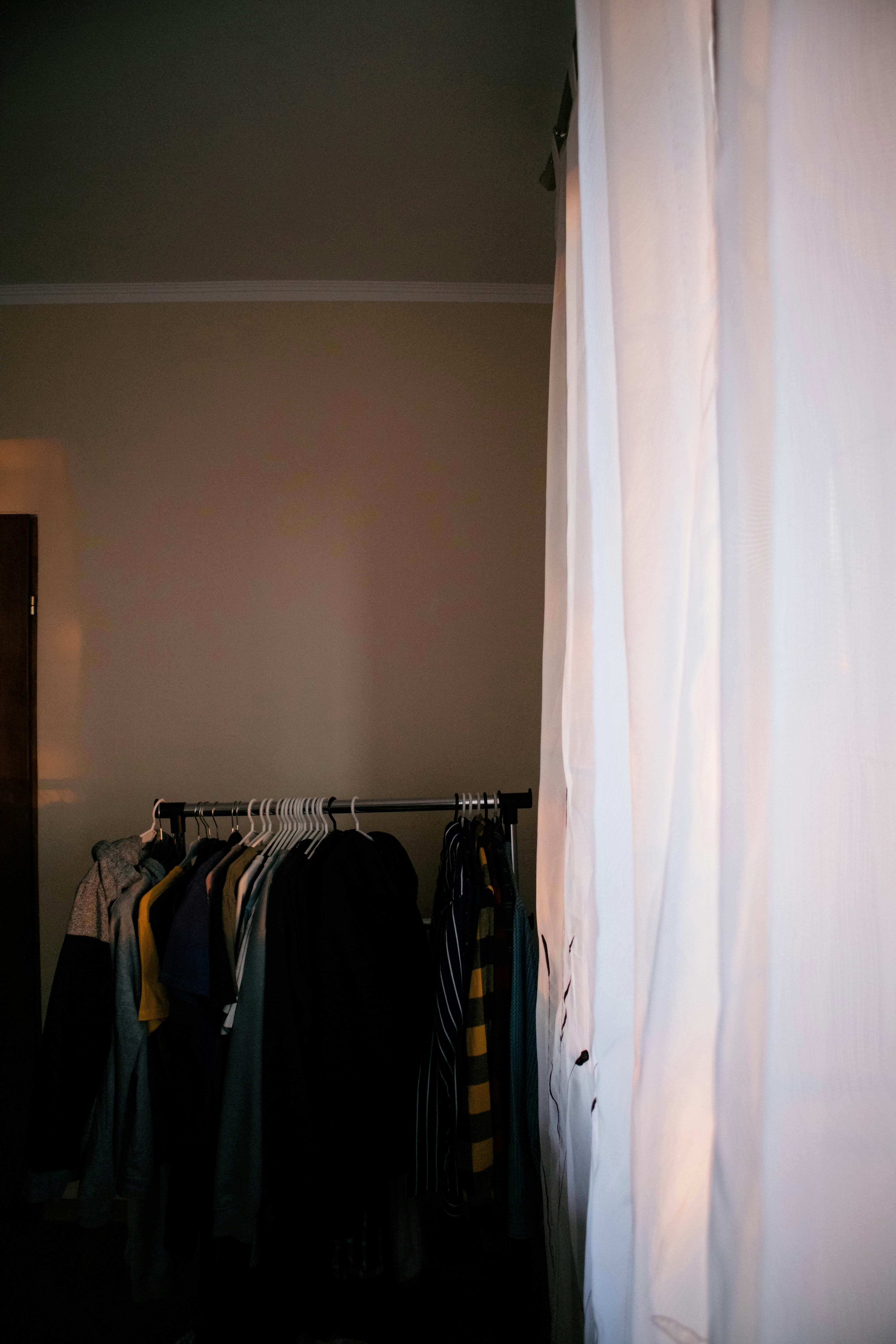a closet with clothes hanging on a rail