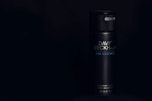 A sleek aluminum-free deodorant stick resting on a bed of coconut shells and vanilla beans.