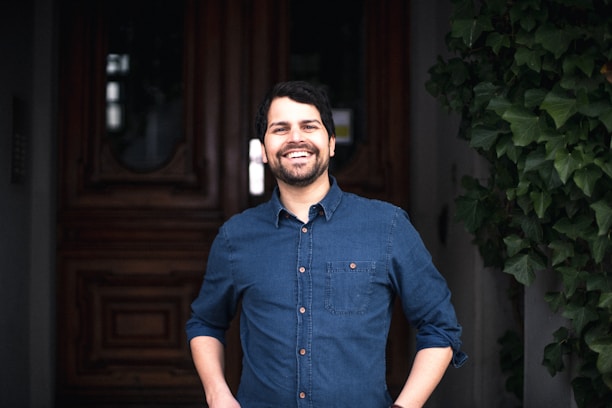 A confident salesperson knocking on a residential door with a bright smile, holding fiber internet brochures.