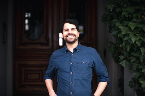 A cheerful host welcoming guests with a genuine smile at the front door.