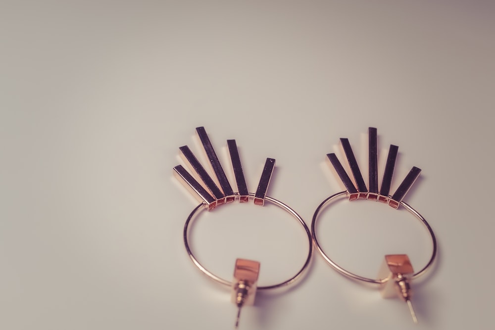 a close up of a pair of earrings on a white surface