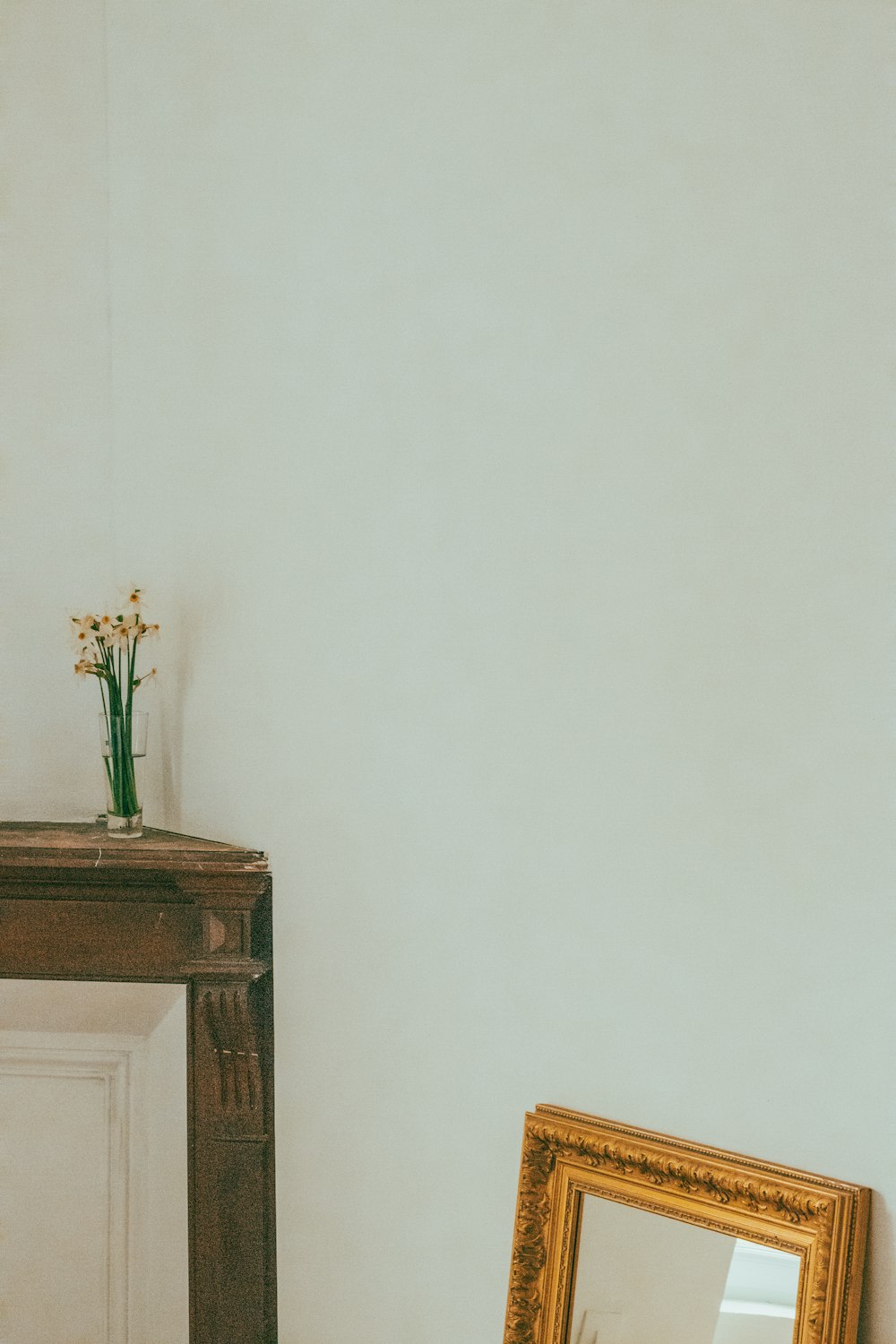 a mirror and a vase of flowers on a table