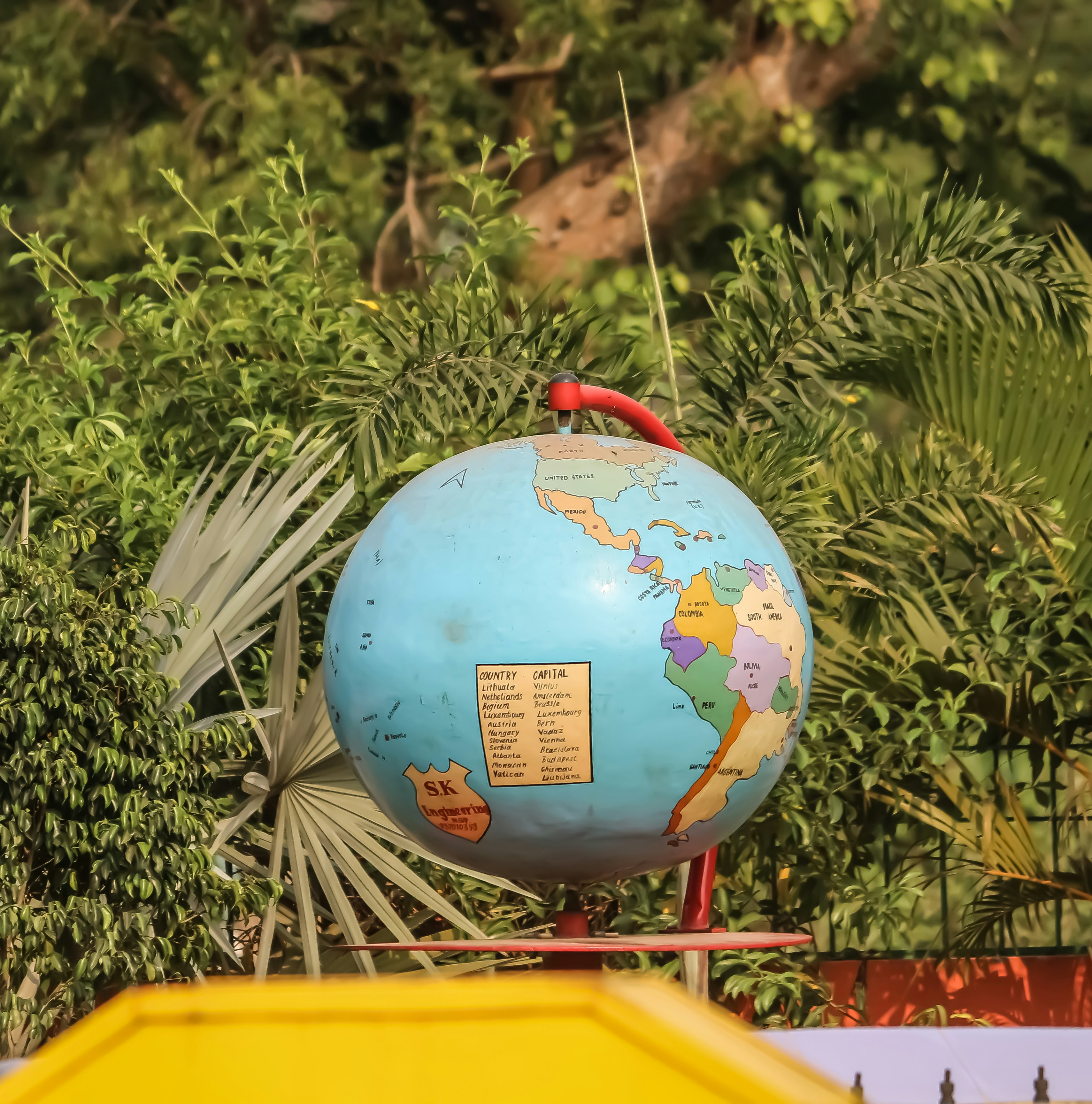 a large blue globe sitting on top of a metal stand