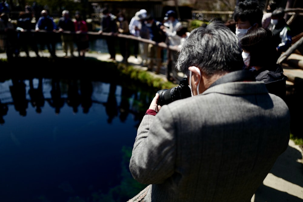 a man taking a picture of a pond