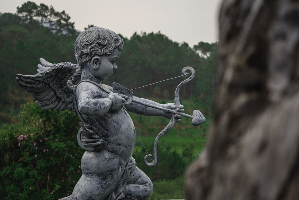 una statua di un Cupido che tiene un arco e una freccia