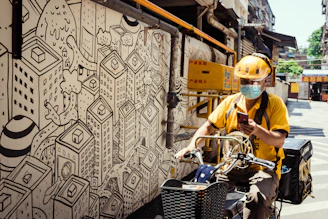 A motoboy checking his smartphone while taking a quick break on the city street.