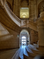 a staircase in a building with a clock on the wall