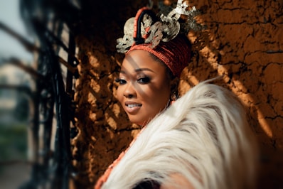 a woman wearing a headdress standing next to a wall