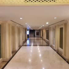 A spotless condominium hallway with polished floors and bright lighting.