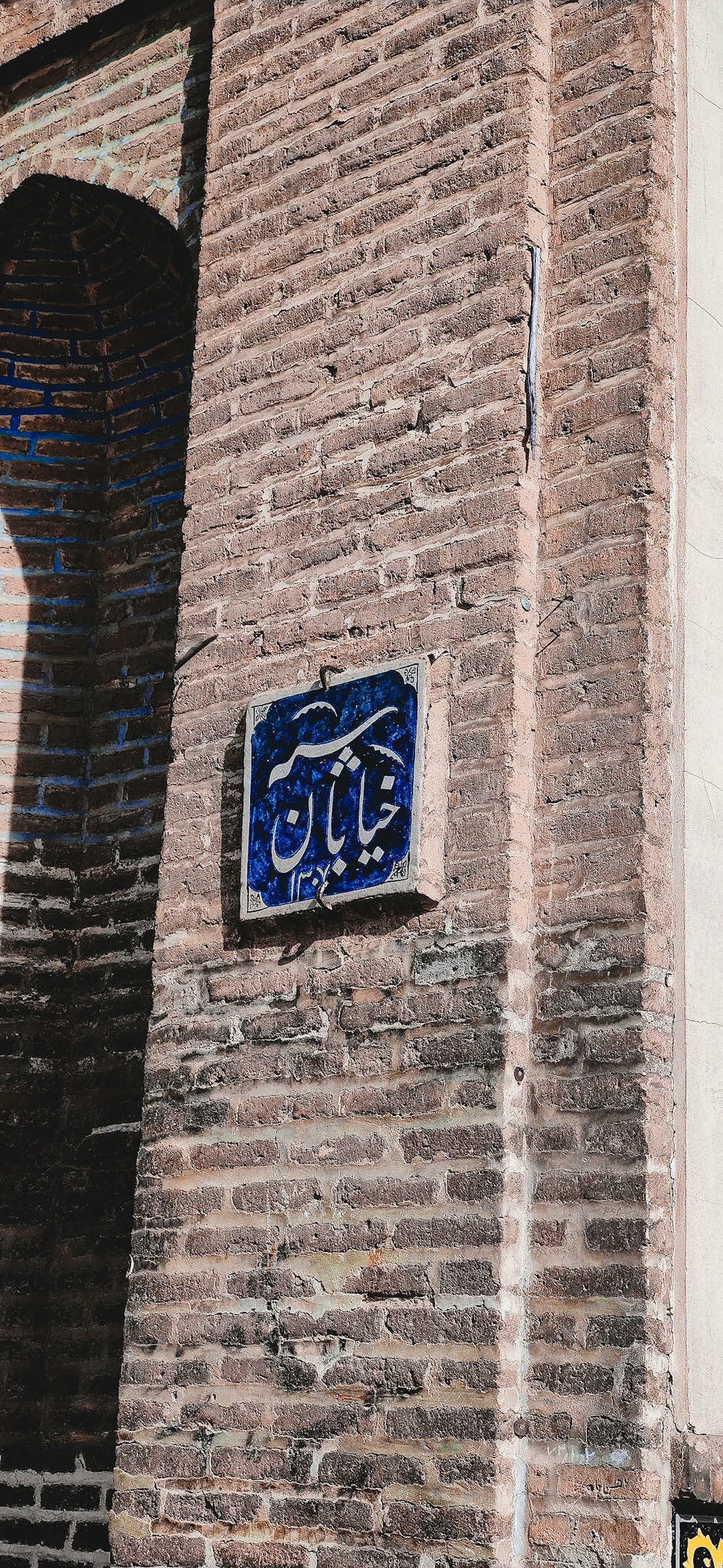 a brick building with a blue sign on it