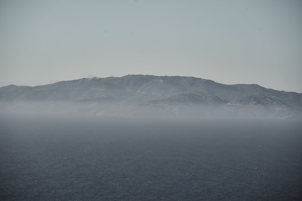 a large body of water with a mountain in the background