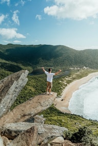 a man standing on top of a rock near the ocean