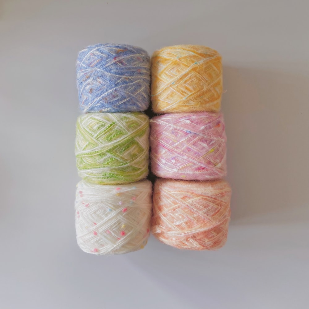 four skeins of multicolored yarn sitting on top of each other