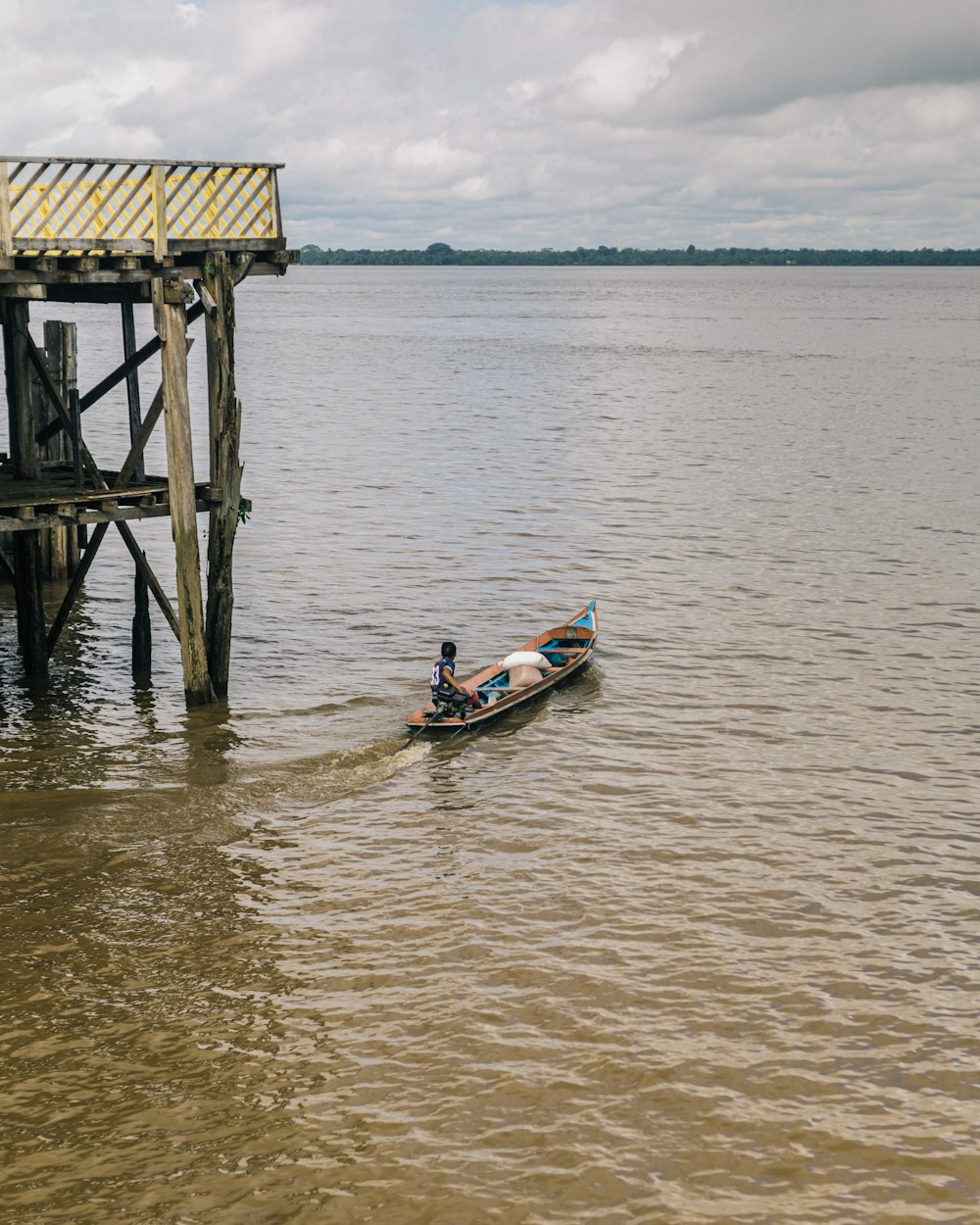 a man in a small boat on a body of water