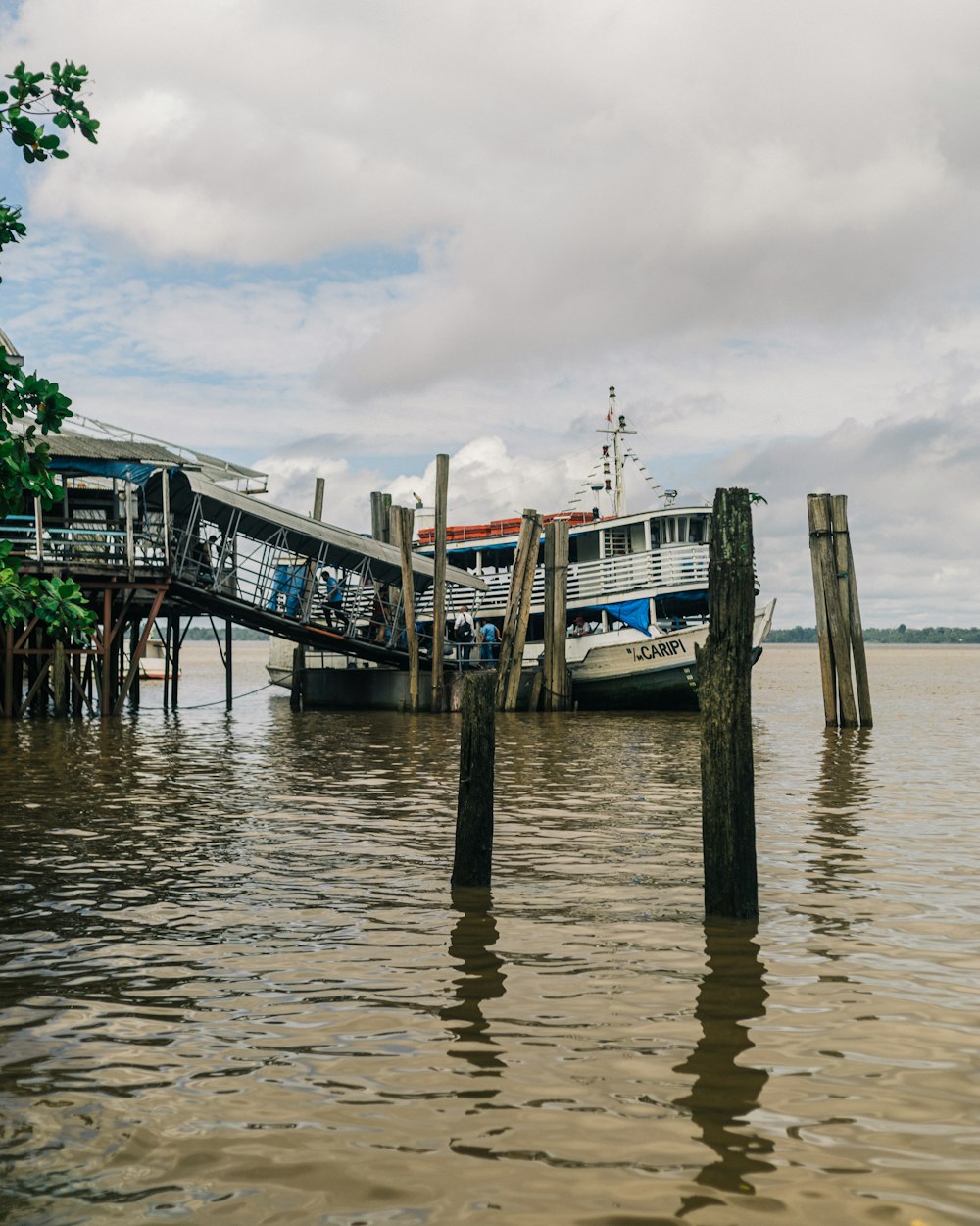 a boat is docked at a pier on a cloudy day