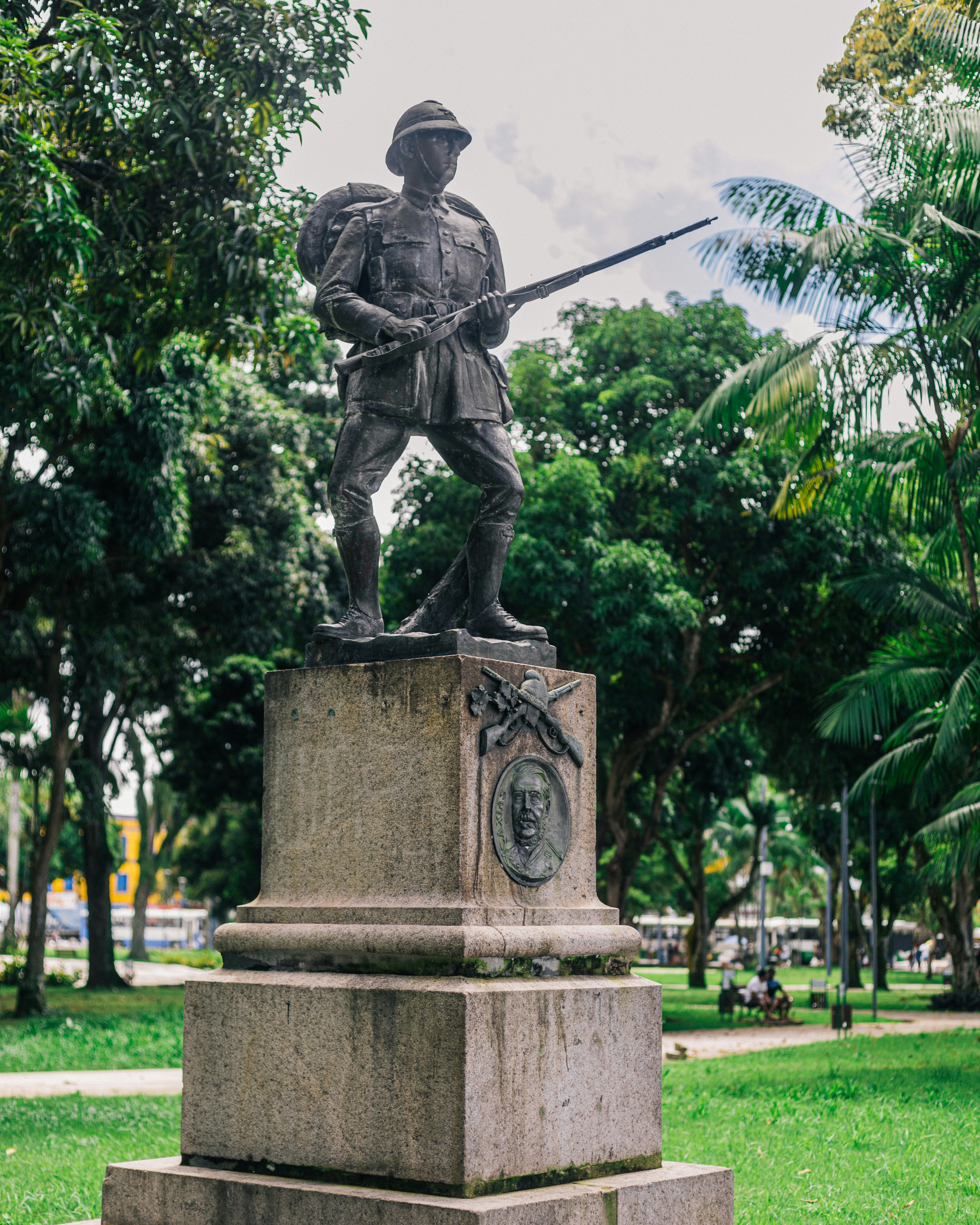uma estátua de um homem segurando uma espada em um parque
