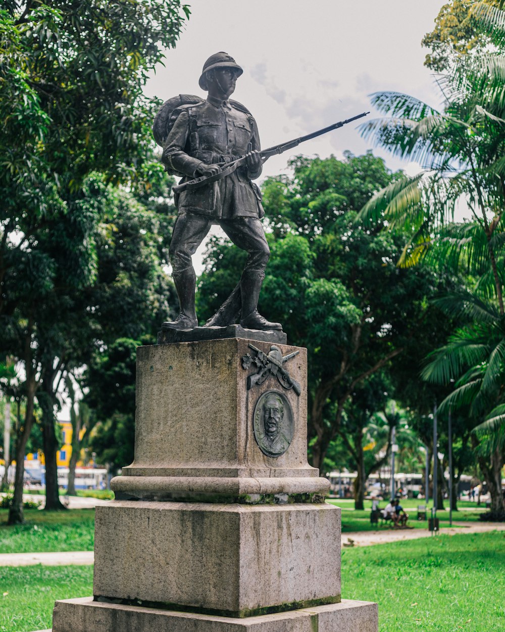 a statue of a man holding a sword in a park