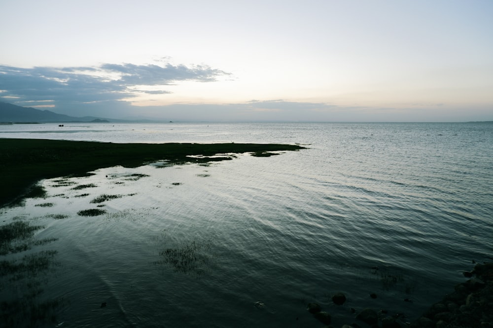 a body of water with a sky in the background