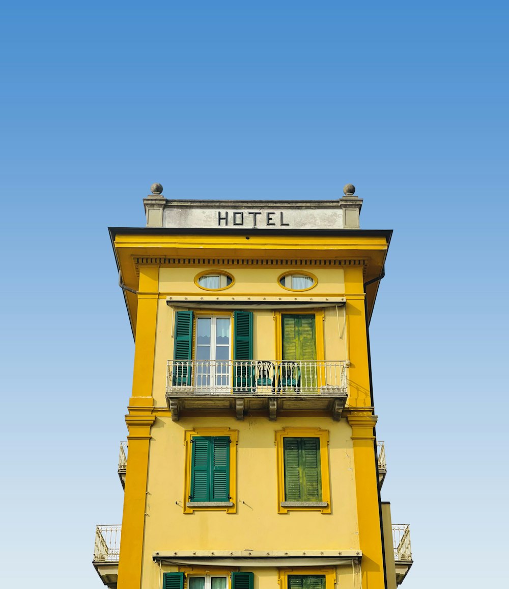 a tall yellow building with a balcony and balconies