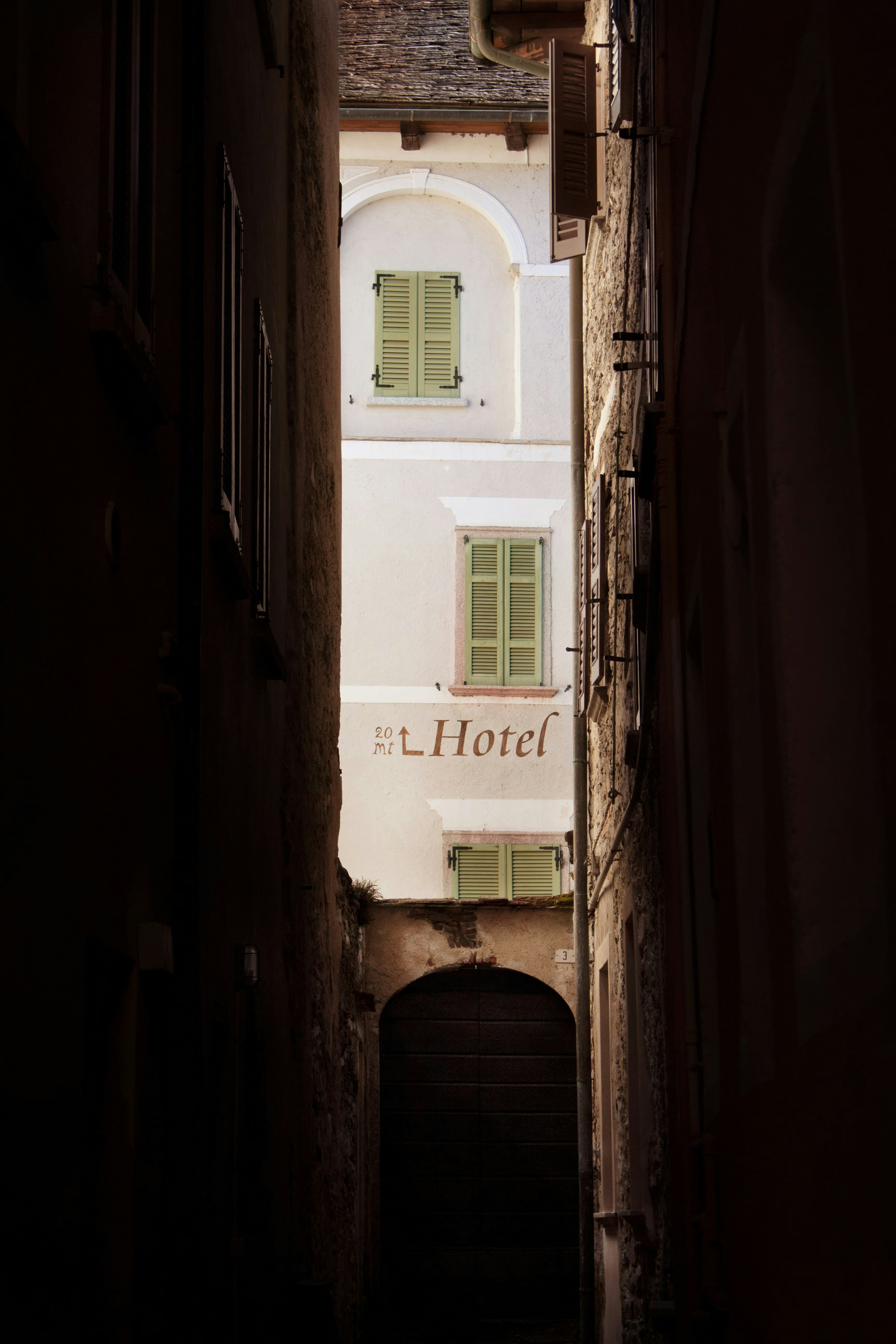 a narrow alley way with a hotel sign on it