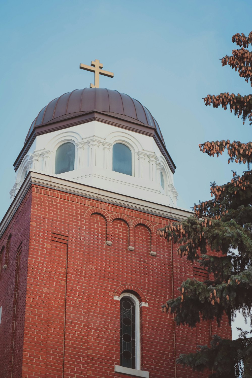 a large brick building with a cross on top