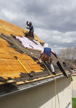 a couple of men working on a roof