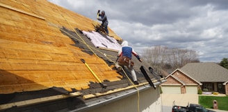 a couple of men working on a roof