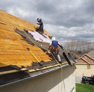 a couple of men working on a roof