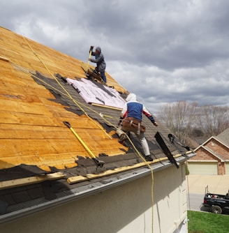 a couple of men working on a roof