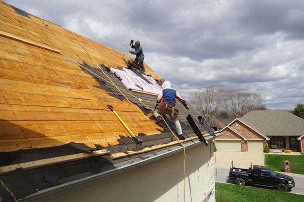 a couple of men working on a roof