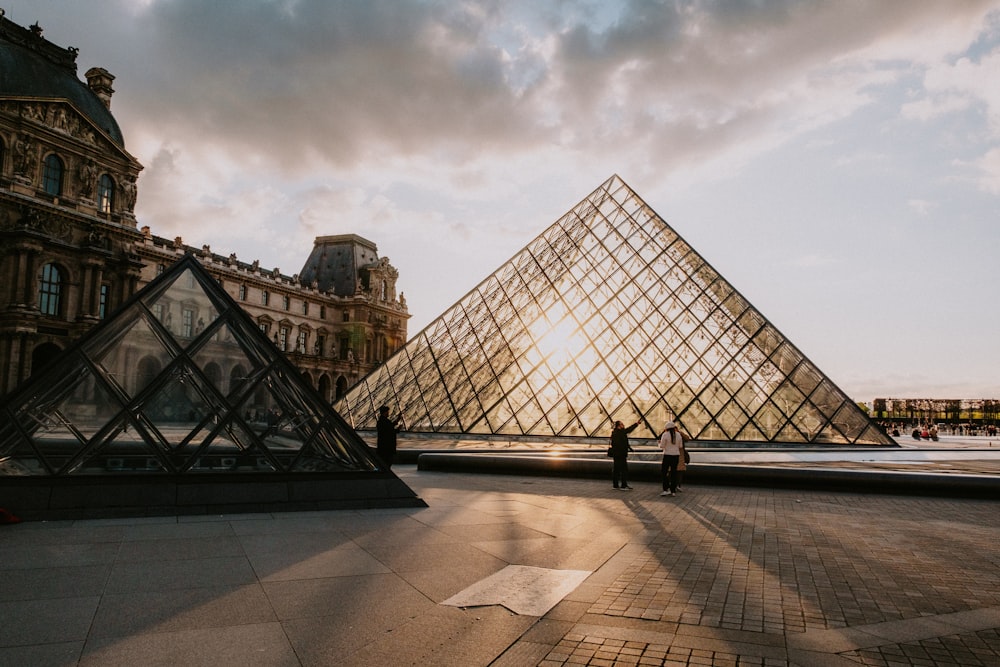 a couple of people standing in front of a pyramid