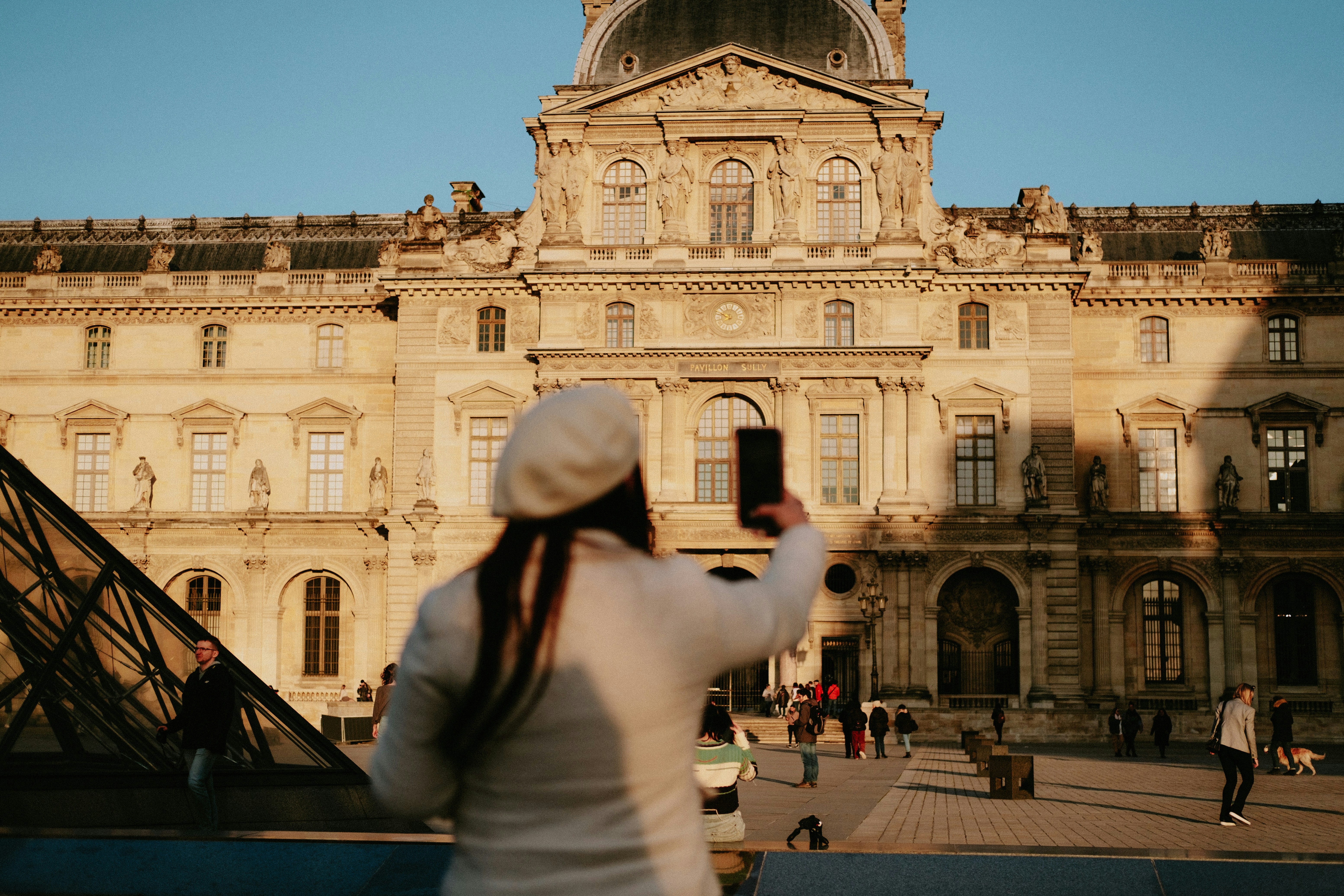 a woman taking a picture of a large building