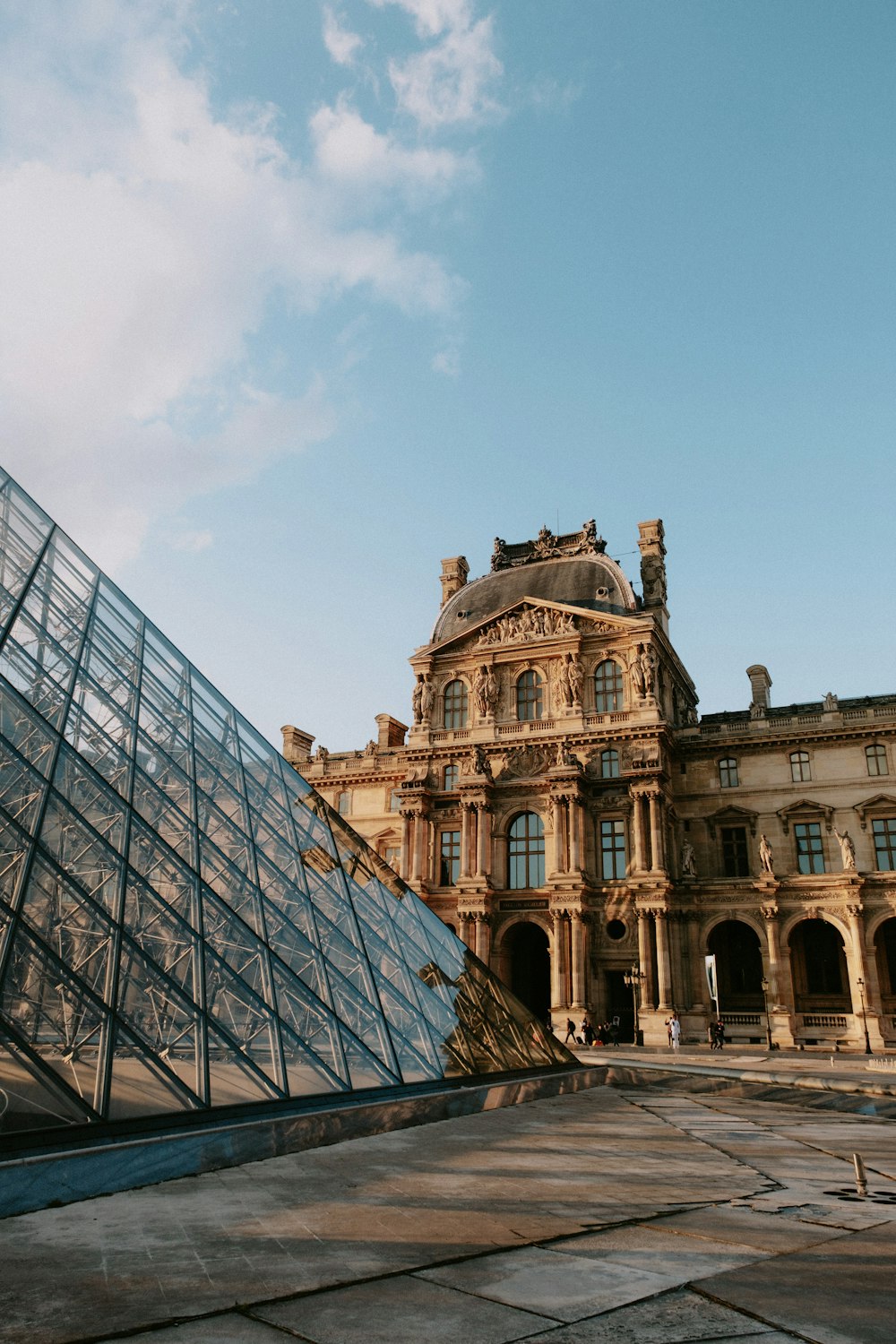 a large building with a glass pyramid in front of it